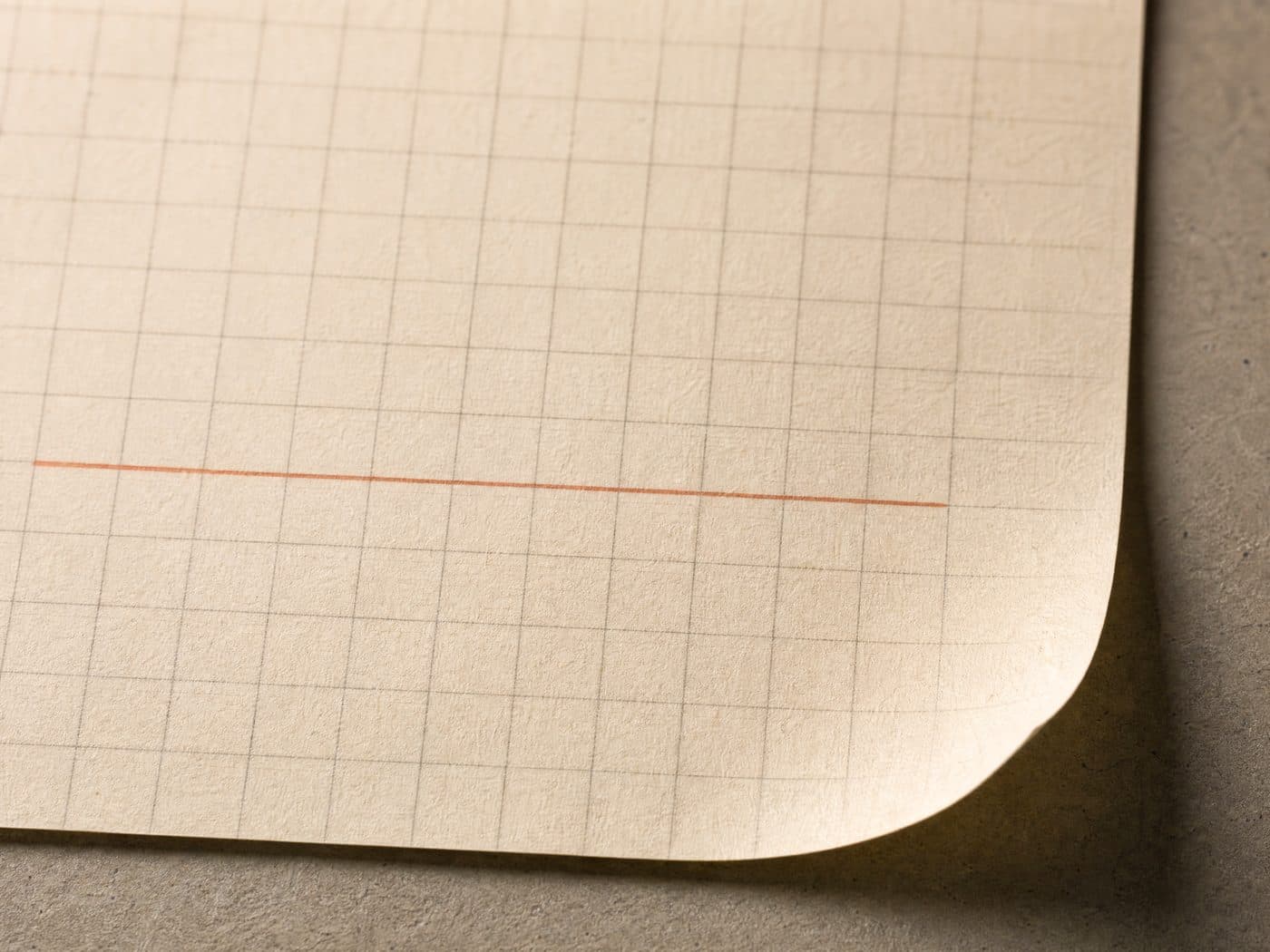 A sheet of fine graph paper with a thin orange pencil line across a few squares.